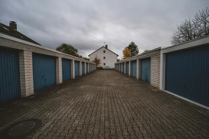 Garagenhof mit Toren links und rechts einer gepflasterten Gasse